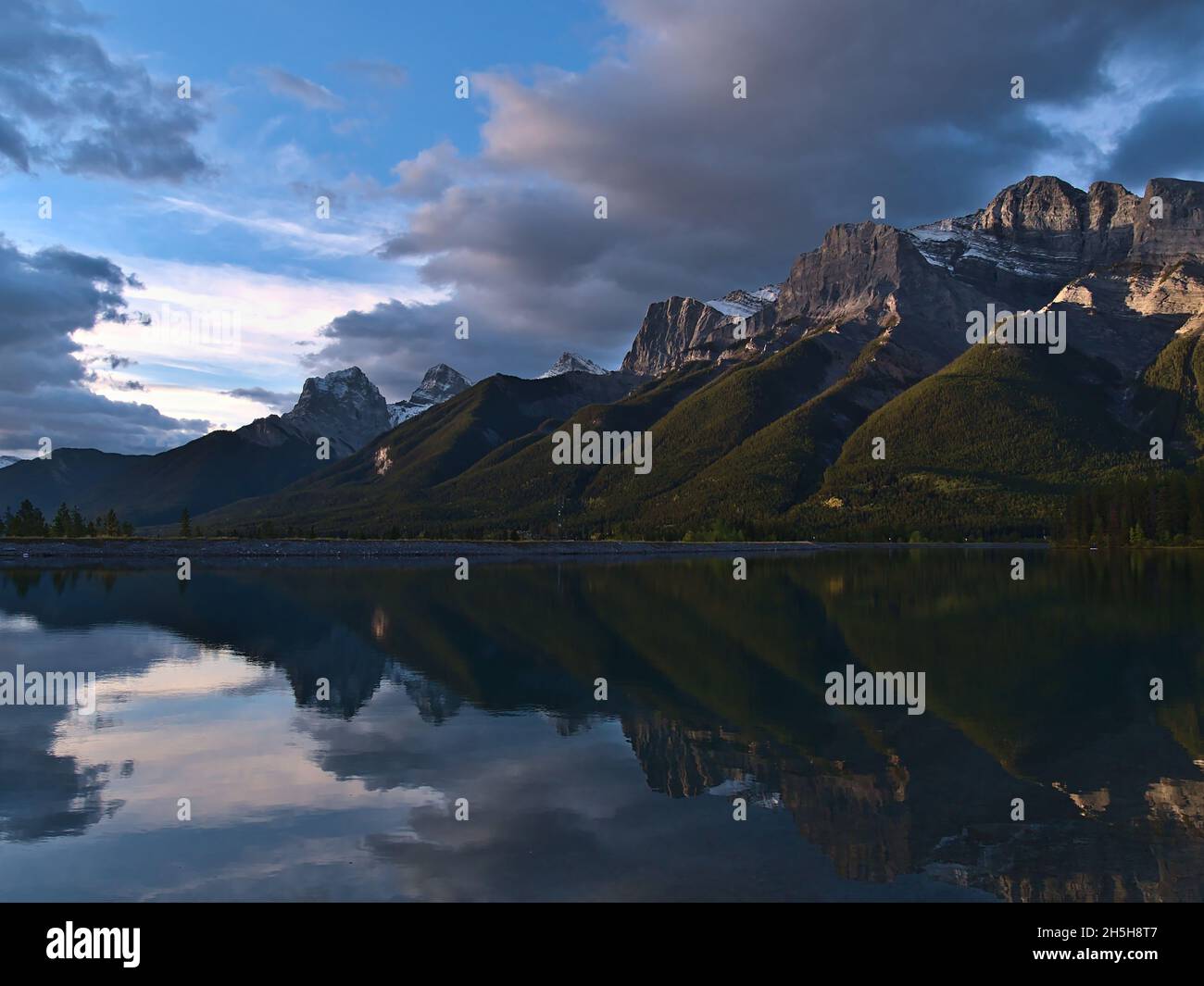 Blick auf das Ehagay Nakoda-Massiv bei Canmore, Alberta, Kanada in den Rocky Mountains mit Mount Lawrence Grassi nach Sonnenaufgang im Wasser. Stockfoto