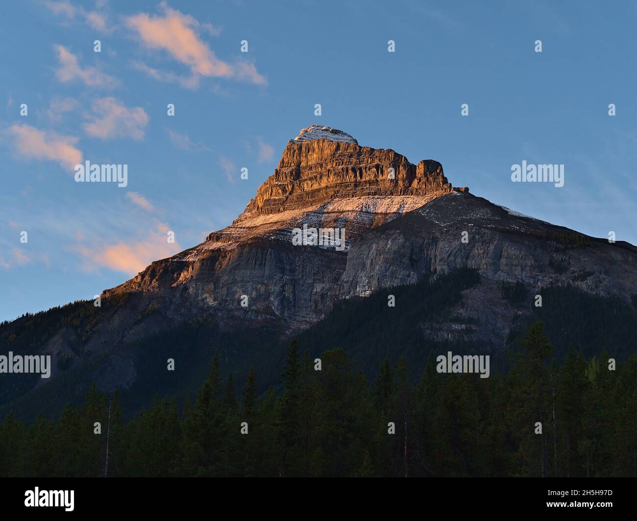 Wunderschöne Aussicht auf den majestätischen, zerklüfteten Pilot Mountain mit steilen Felswänden und Schnee im orangefarbenen Morgenlicht in der Herbstsaison. Stockfoto