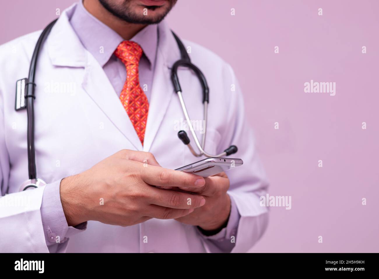 Medizinische App Smartphone in den Händen von Male Doctor auf isoliertem Hintergrund, selektiver Fokus auf Gerät. Stockfoto