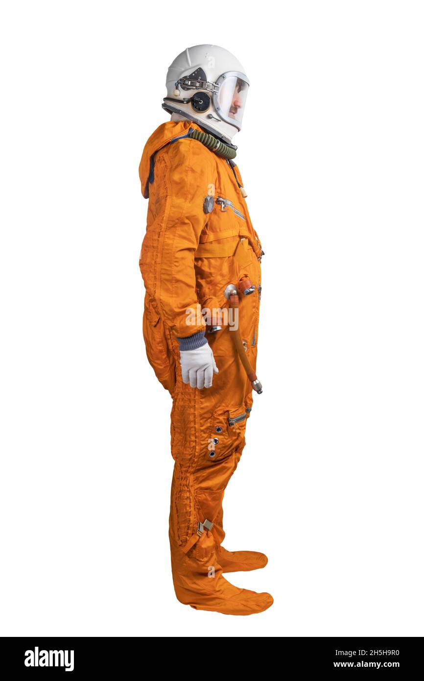 Astronaut trägt einen orangefarbenen Raumanzug und einen Weltraumhelm, der auf weißem Hintergrund isoliert ist. Seitenansicht Stockfoto