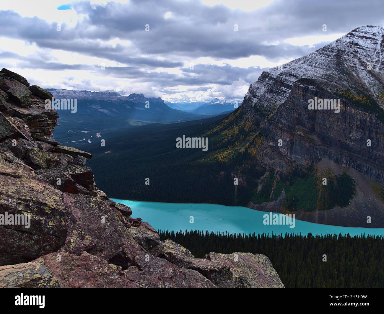 Panoramablick über den berühmten Lake Louise mit türkisfarbenem Wasser und das Bow Valley im Herbst mit felsiger Front im Banff National Park, Kanada. Stockfoto