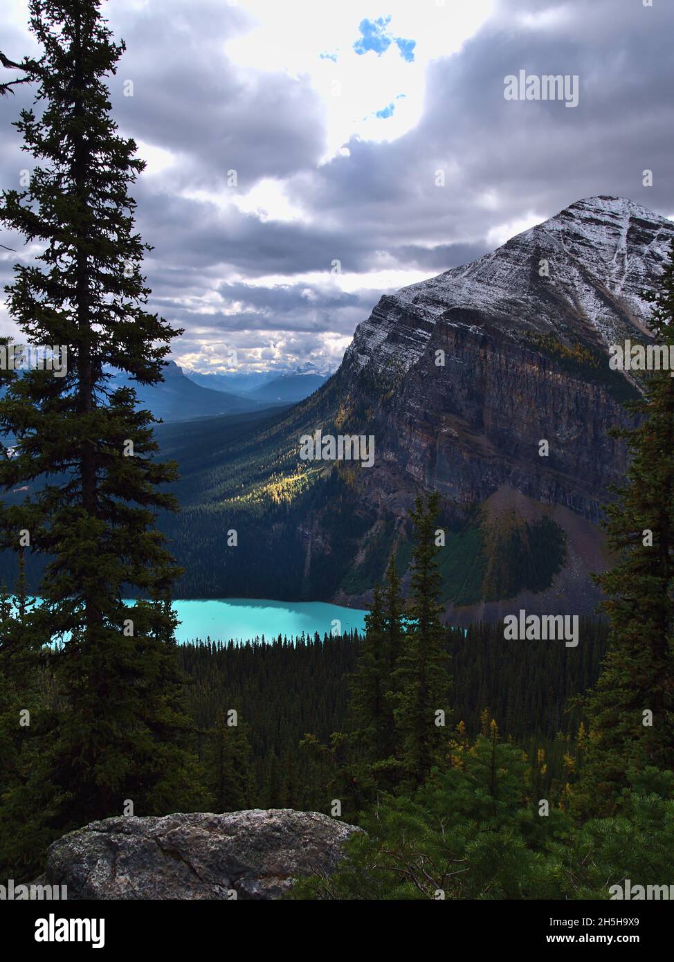 Portraitansicht des Lake Louise im Herbst in den Rocky Mountains im Banff National Park, Alberta, Kanada mit der zerklüfteten Felswand des Fairview Mountain. Stockfoto
