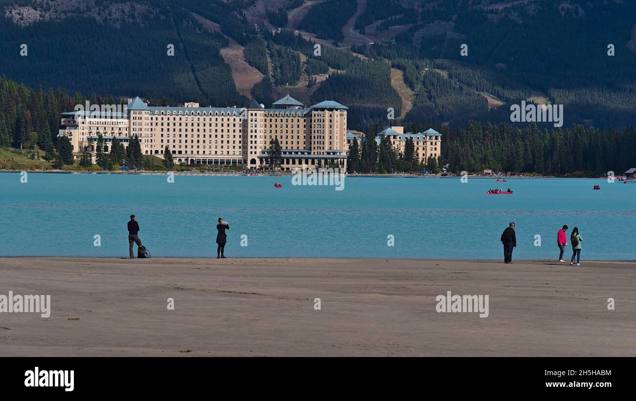 Touristen, die sich am westlichen Ufer des türkisfarbenen Lake Louise im Banff National Park, Alberta, Kanada, in den Rocky Mountains Vergnügen. Stockfoto
