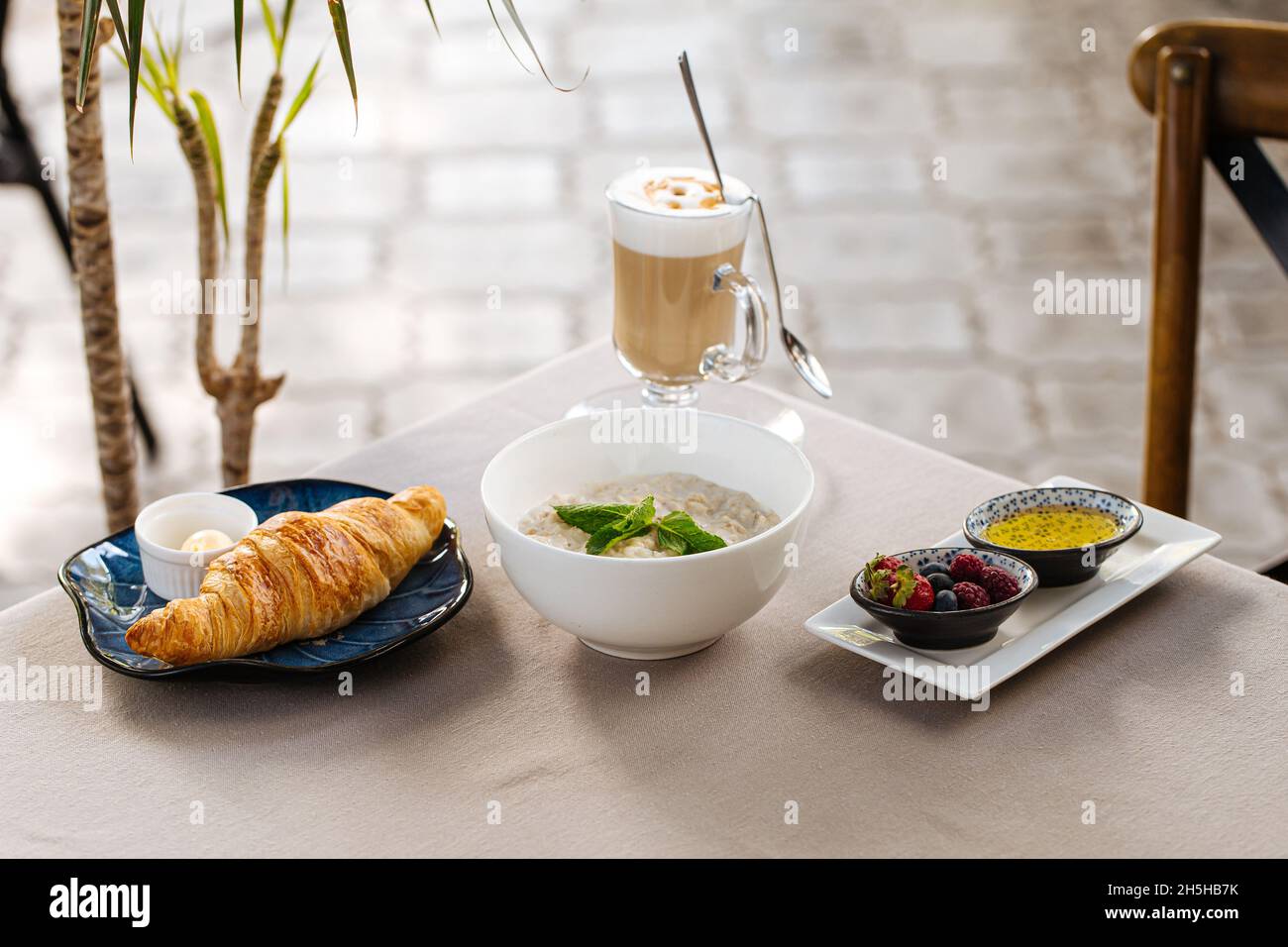 Serviert Frühstück mit Haferbrei und Croissant Stockfoto