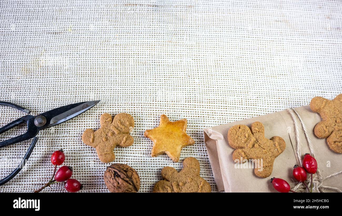 Home Backed Ingwer Mann Cookies, Dekoration für Weihnachten, Schere, auf einem rustikalen Stoff Hintergrund. Nahaufnahme. Stockfoto