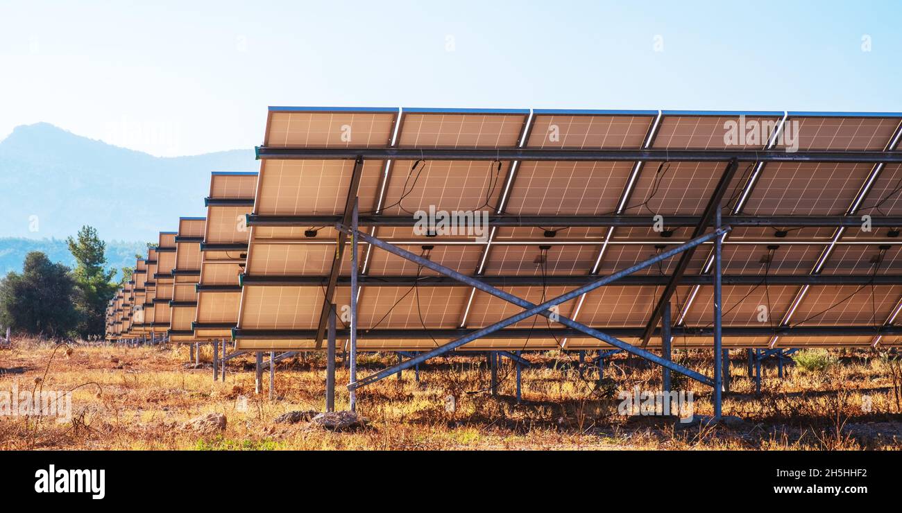 Ein Komplex von Sonnenkollektoren zur Stromerzeugung. Grüner Energiepark. Hintergrund mit Platz für Text oder Beschriftungen. Ökologisches Konzept. Stockfoto