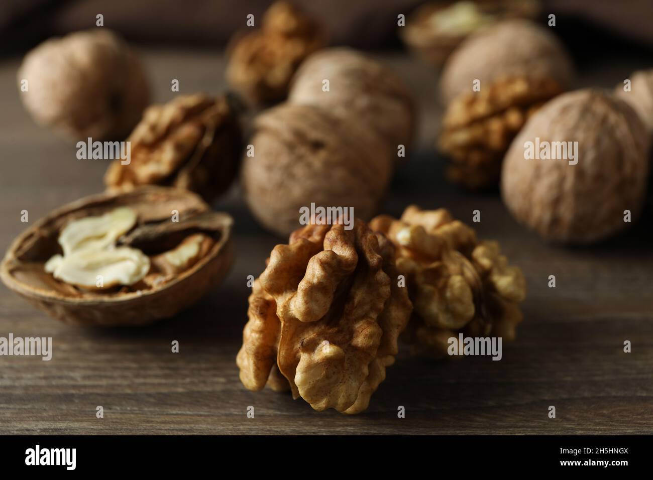 Walnüsse mit Küchentuch auf Holzhintergrund Stockfoto