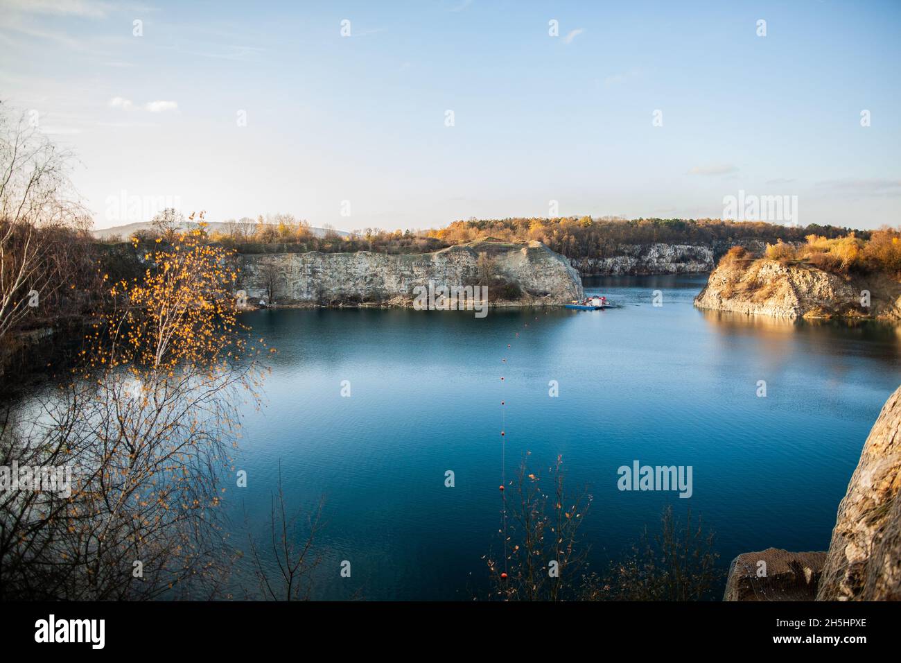 Wunderschöne Landschaft mit blauem Wasser, umgeben von Felsklippen mit Herbstbäumen auf der Spitze, künstlichem Wasserreservoir, ehemaligem Kalksteinbruch in Krakau Stockfoto