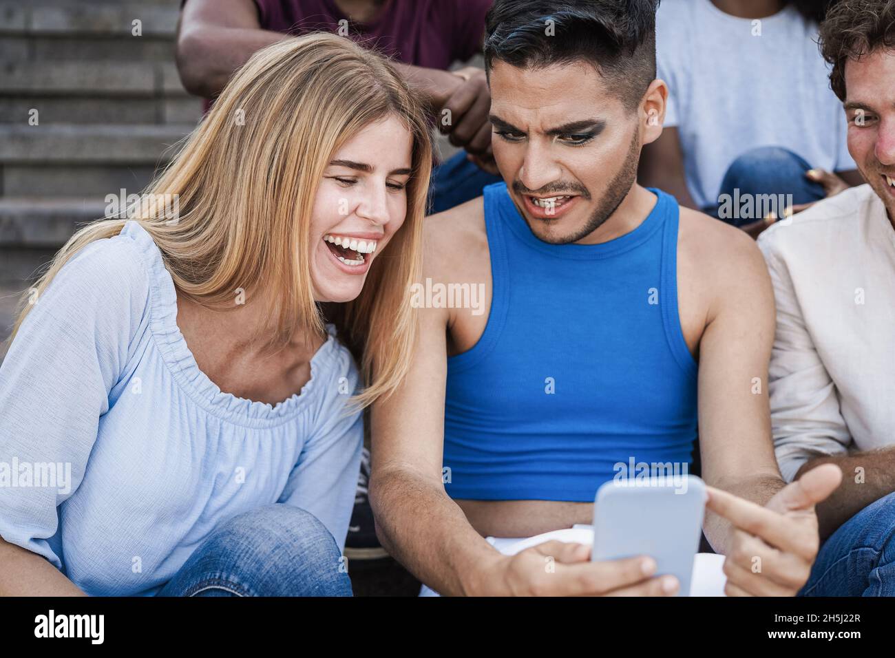 Junge Menschen mit Handys im Freien in der Stadt - Fokus auf Transgender Mann Gesicht Stockfoto