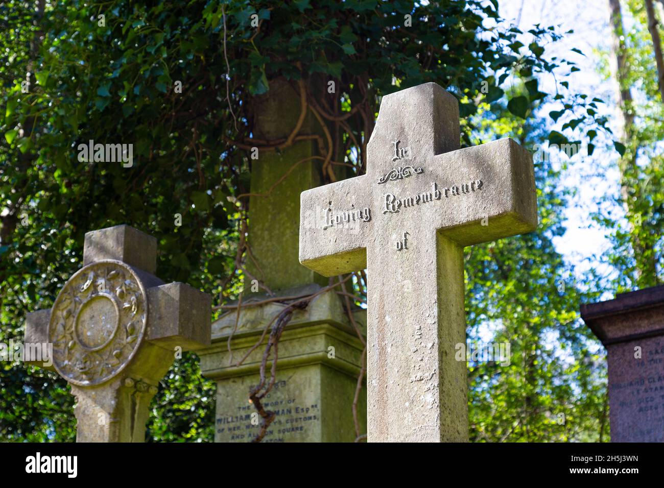 Gechiptes Kreuz mit dem Text „in Loving Remembrance of“ auf dem Highgate Cemetery West, London, Großbritannien Stockfoto