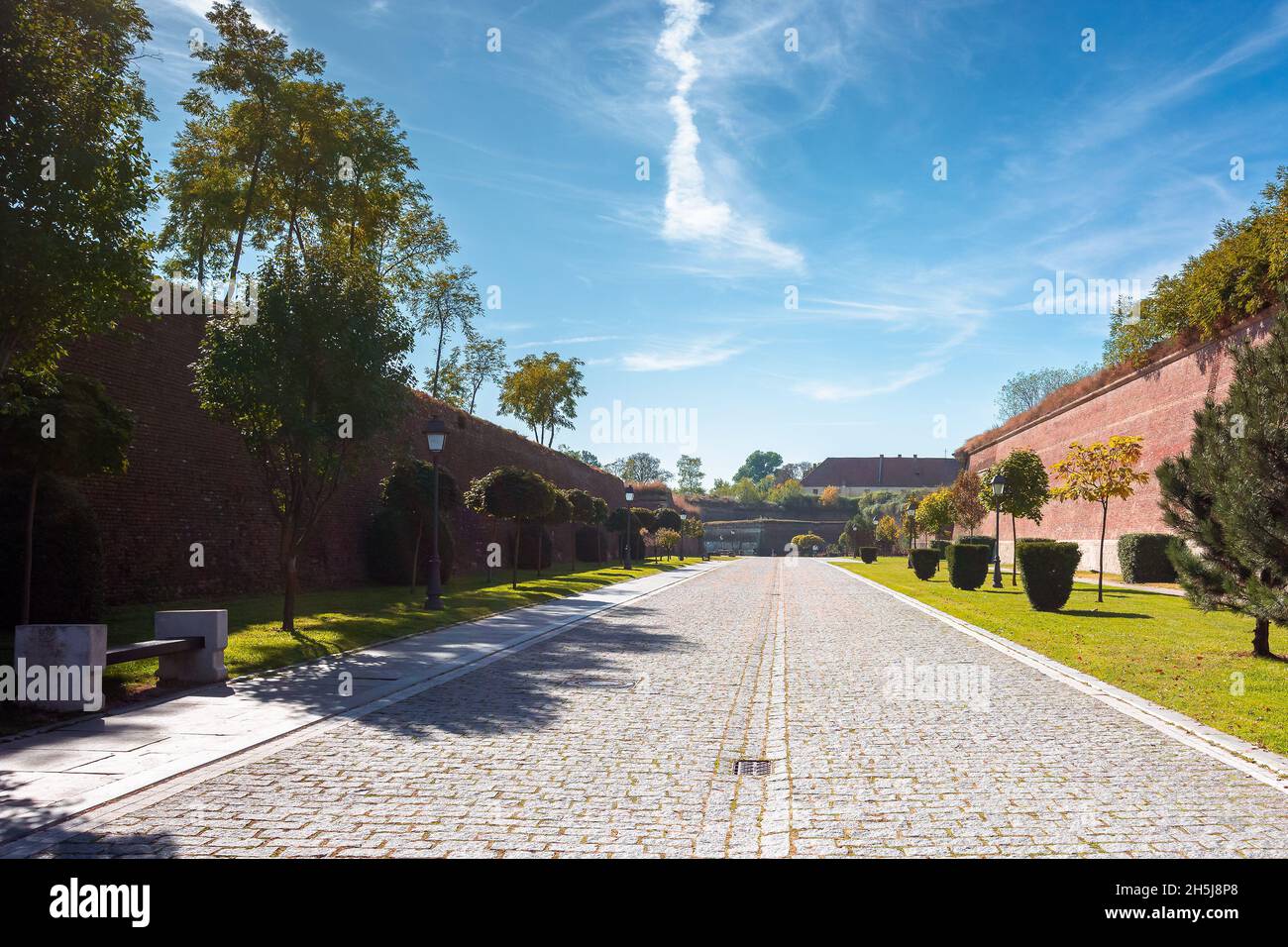 alba-iulia, rumänien - Okt 13, 2019: Innenstraßen der Zitadelle von Alba carolina im Herbst. Laternen und Bänke am Gehweg. Riesige Mauern um den Weg. Stockfoto