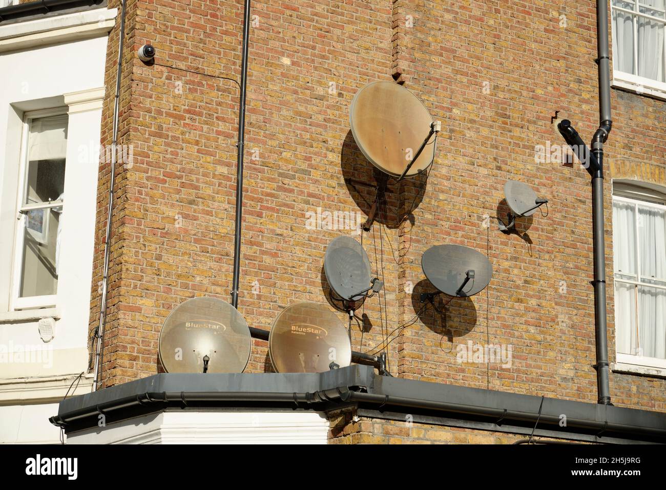 Eine Reihe von Satellitenschüsseln unterschiedlicher Größe in einem Londoner Wohnhaus. Stockfoto