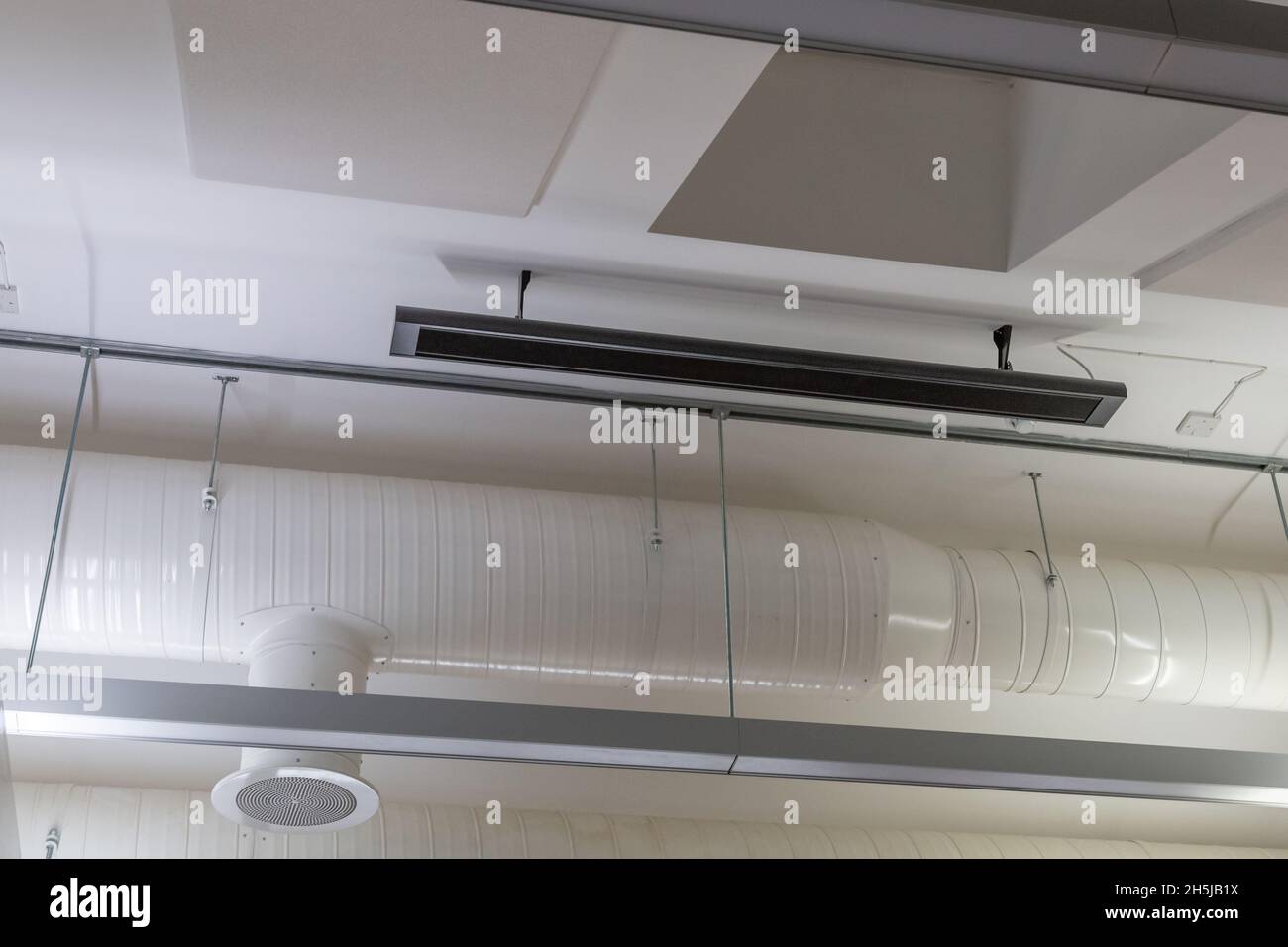 In einem Niedrigenergiegebäude in Yorkshire, England, hing eine Infrarot-Heizplatte an einer Decke. Umweltfreundliche Heizung. Stockfoto