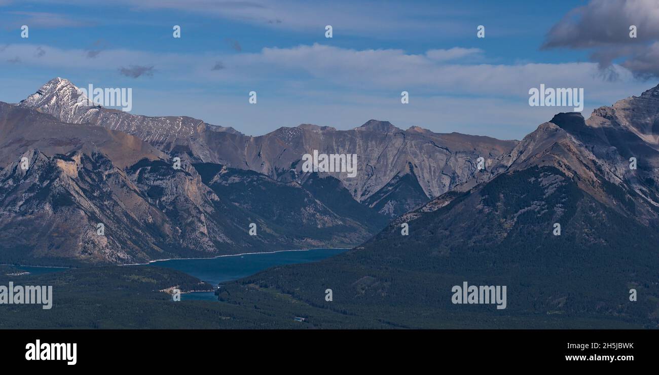 Panoramablick auf die rauen Rocky Mountains östlich von Banff, Banff National Park, Alberta Kanada mit Lake Minnewanka dazwischen und Wäldern im Tal. Stockfoto