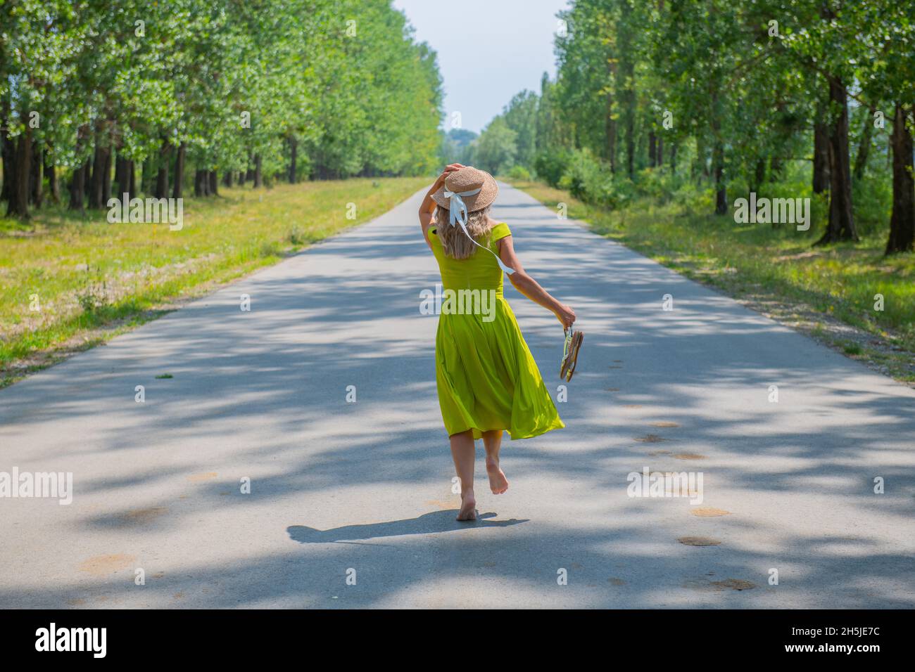 Ein Reisender mit Hut läuft barfuß auf der Straße Stockfoto