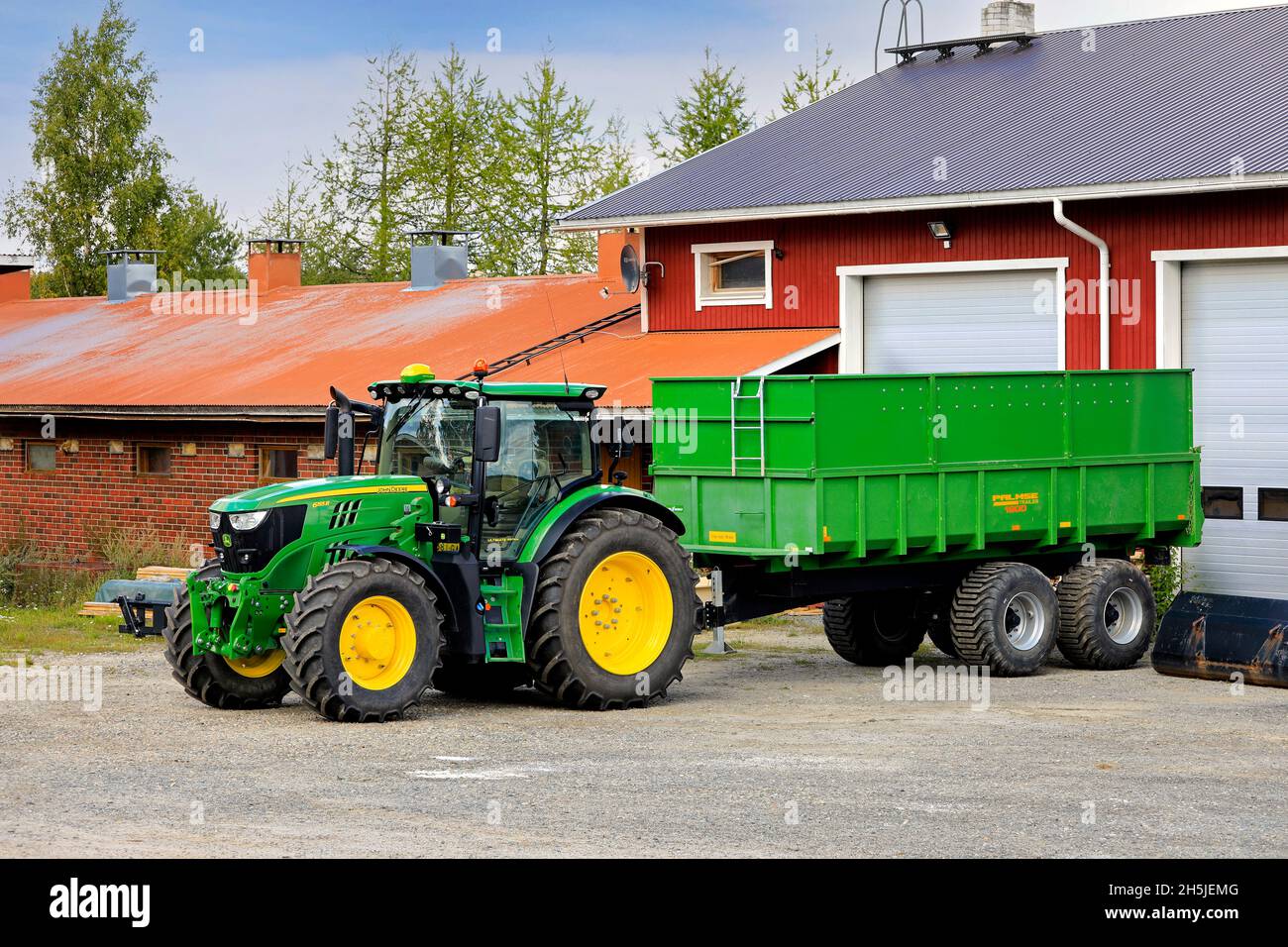 John Deere 6155R Traktor vor dem Palmse 1900 Anhänger auf dem Hof an einem Tag im Frühherbst. Salo, Finnland. 29. August 2020. Stockfoto