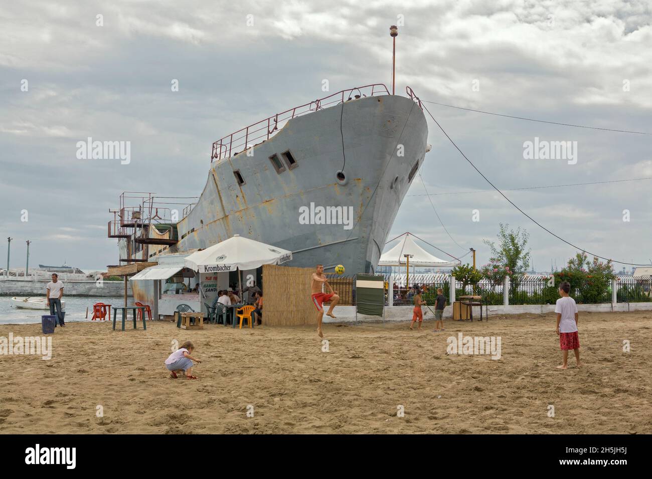 Ein Schiff, das auf Grund gelaufen war, steht jetzt aufrecht und dient als Unterstand am Strand von Durrës. Stockfoto