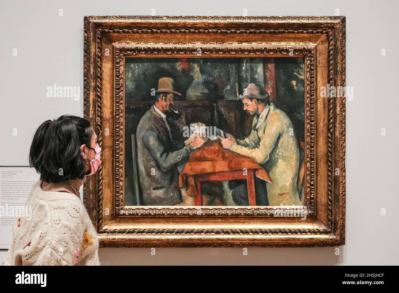 London, Großbritannien. November 2021. Mitarbeiter der Galerie mit Paul Cezanne, „The Card Players“ (1894-95=. Die Courtauld Gallery im Somerset House in London wird am Freitag, dem 19. November, nach dem bedeutendsten Modernisierungsprojekt in der Geschichte der Stadt wieder für die Öffentlichkeit zugänglich sein und eine der größten Kunstsammlungen des Vereinigten Königreichs beherbergt. Kredit: Imageplotter/Alamy Live Nachrichten Stockfoto