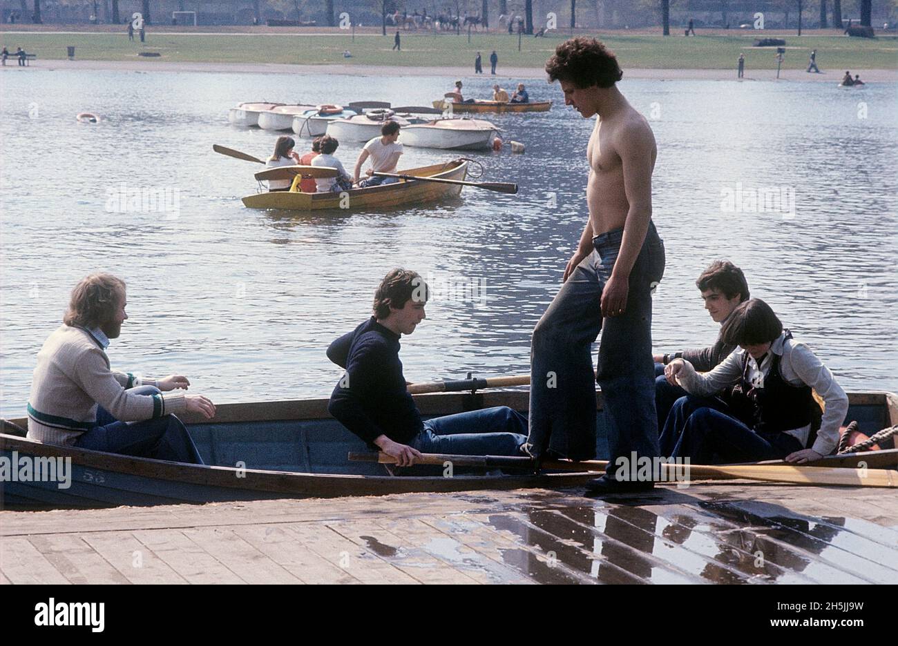 London 1982. Ein Londoner Park und Leute, die Ruderboote mieten. Ein Mann in einer breiten Jeans vorne. Kredit Roland Palm. Stockfoto