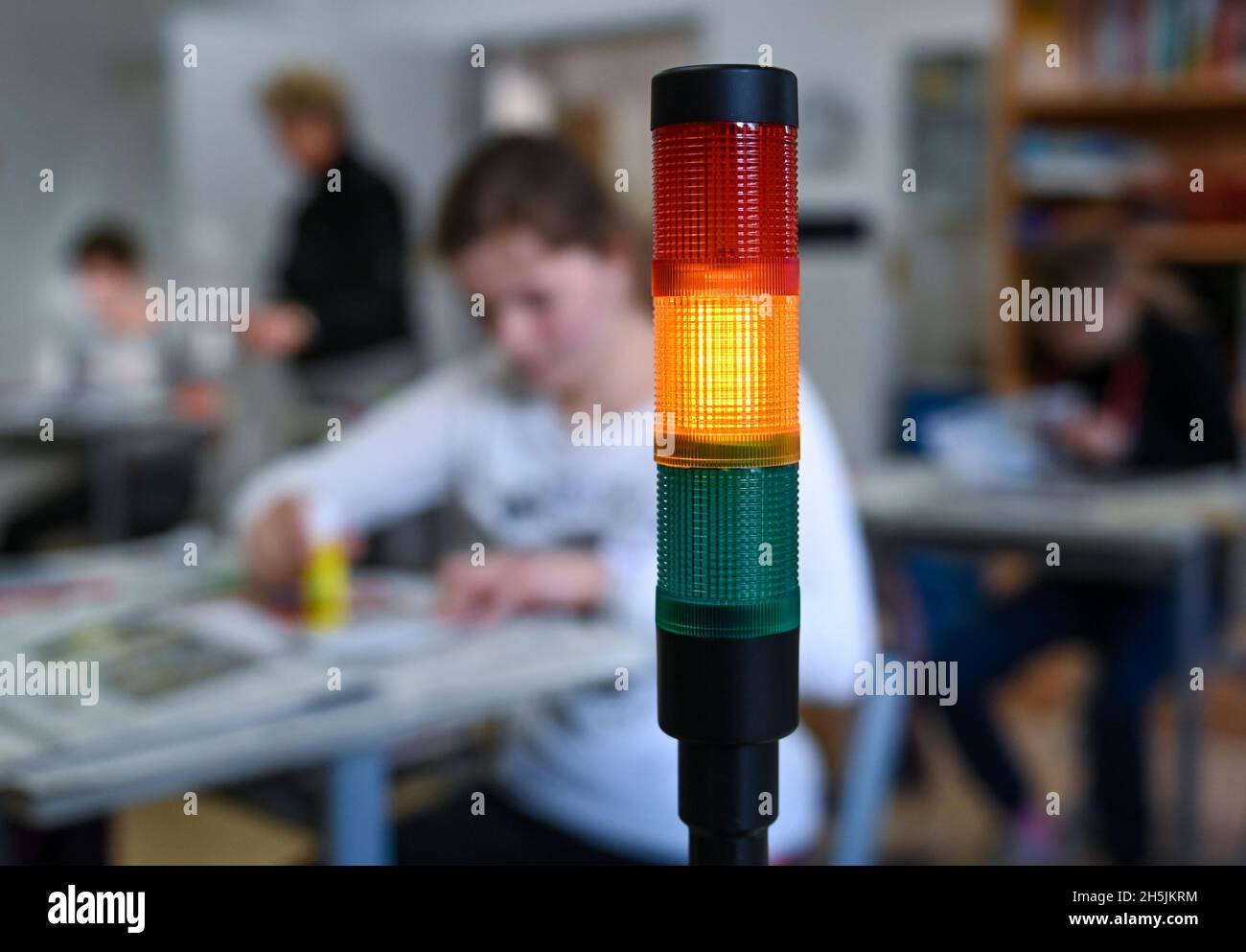 Naumburg, Deutschland. November 2021. In einem Klassenzimmer der Käthe Kruse Schule in Naumburg leuchtet eine sogenannte CO2-Ampel gelb. Das Burgenland hat 135 mobile Raumluftfilteranlagen und über 770 CO2-Ampeln für seine Schulen erworben. Die Investitionen hierfür beliefen sich auf über 600,000 Euro. Die Systeme sind seit Ende der Herbstferien in Betrieb und bieten zusätzlichen Schutz in Zeiten steigender Coronainfektionen. Quelle: Hendrik Schmidt/dpa-Zentralbild/dpa/Alamy Live News Stockfoto