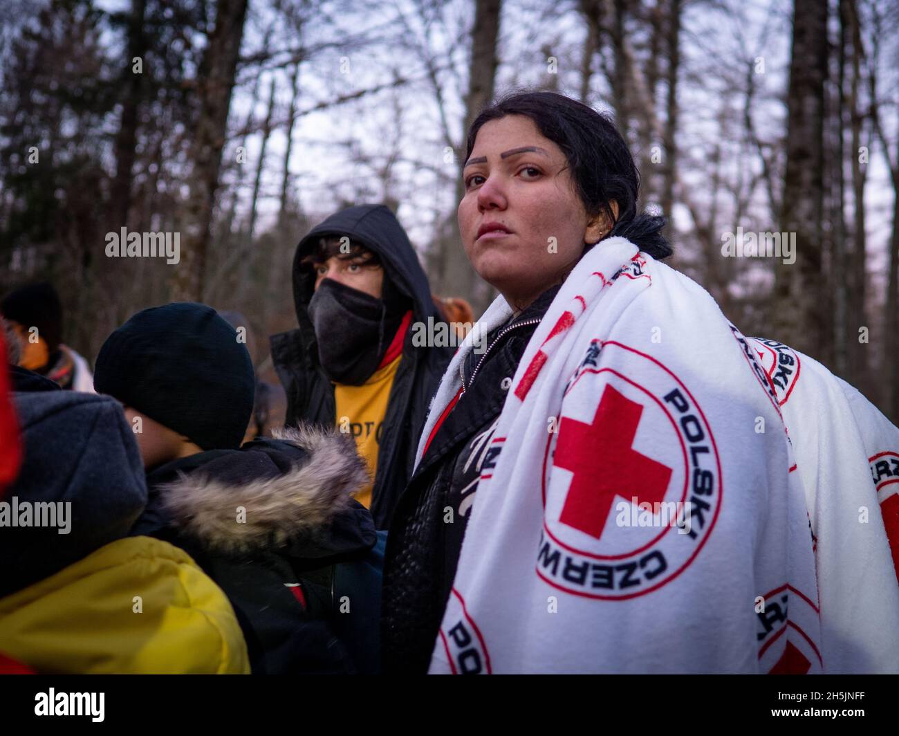 Narewka, Polen. November 2021. Eine junge Frau aus Dohuk mit ihrer Familie wartete darauf, von polnischen Grenzsoldaten begleitet zu werden, nachdem sie Asyl beantragt hatte.Eine siebzehnköpfige Flüchtlingsfamilie, darunter neun Kinder aus Dohuk, Irak, verbrachte siebzehn Tage in einem Wald an der Grenze zu Belarus - Polen und wurde achtmal zurückgedrängt. Verzweifelt mit einem sieben Monate alten Baby und einer älteren Frau mit Beinproblemen beschlossen sie, Aktivisten um Hilfe zu bitten. Kredit: SOPA Images Limited/Alamy Live Nachrichten Stockfoto