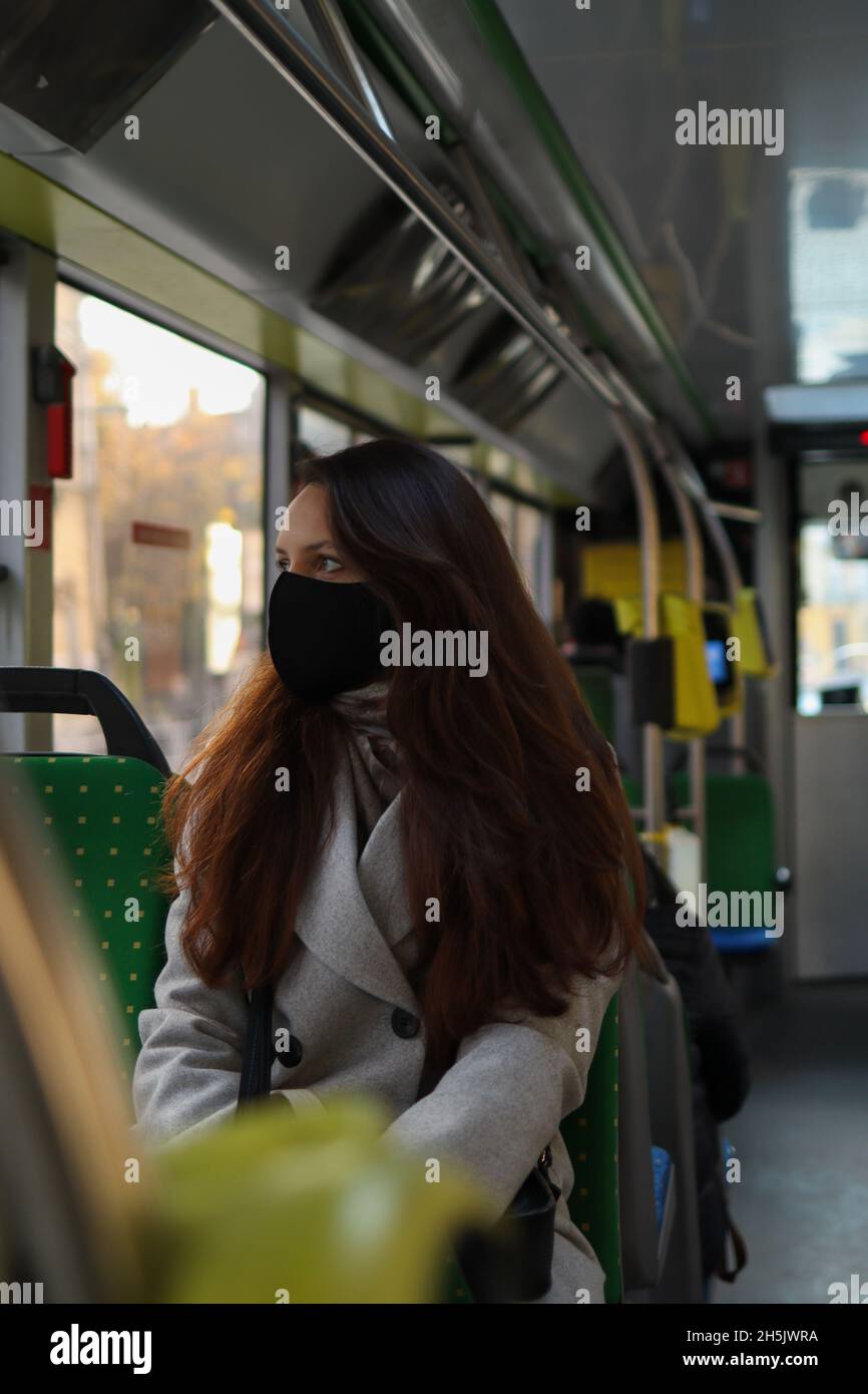 Mehrjährige kaukasische Menschen in Gesichtsmasken-Schutz fahren in einem Bus. Stockfoto
