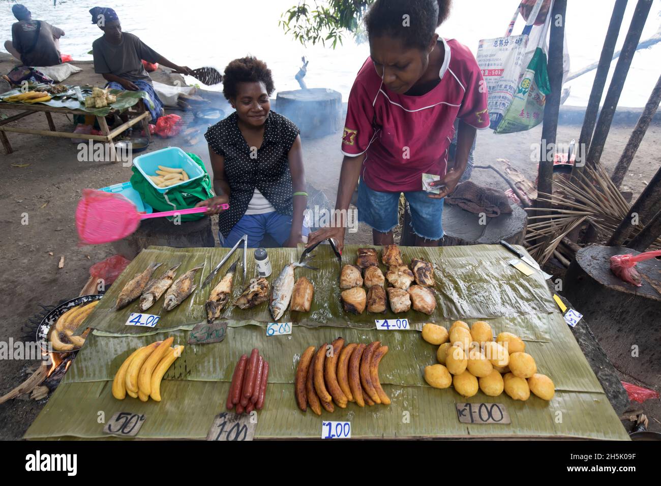 Frauen, die traditionelle Lebensmittel an einem Verkaufsstand auf einem offenen Markt in Madang, Papua-Neuguinea, Madang, Provinz Madang, Papua-Neuguinea verkaufen Stockfoto
