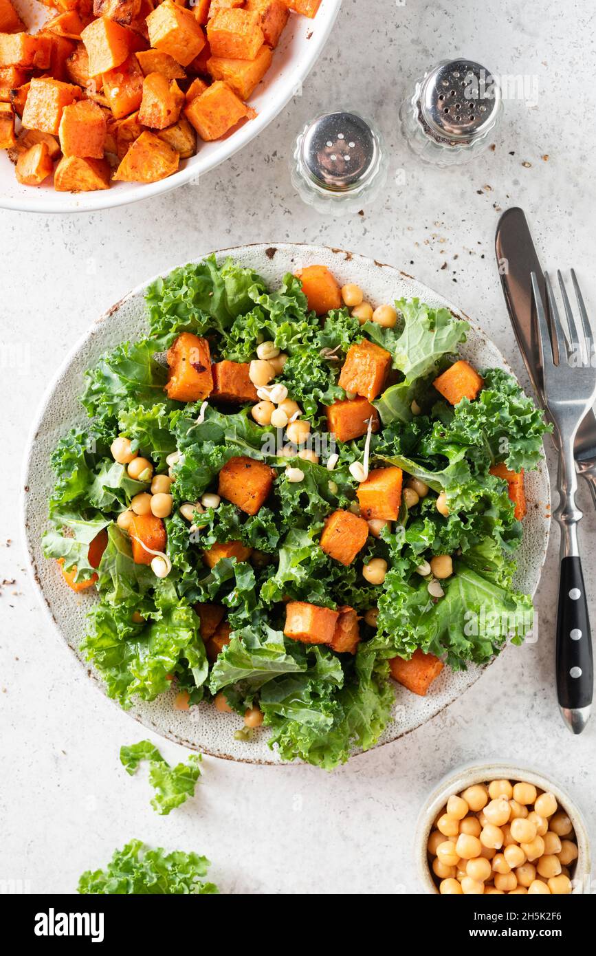 Gesunde vegane Salatschüssel mit Grünkohl, Kichererbsen und Süßkartoffeln. Draufsicht Stockfoto