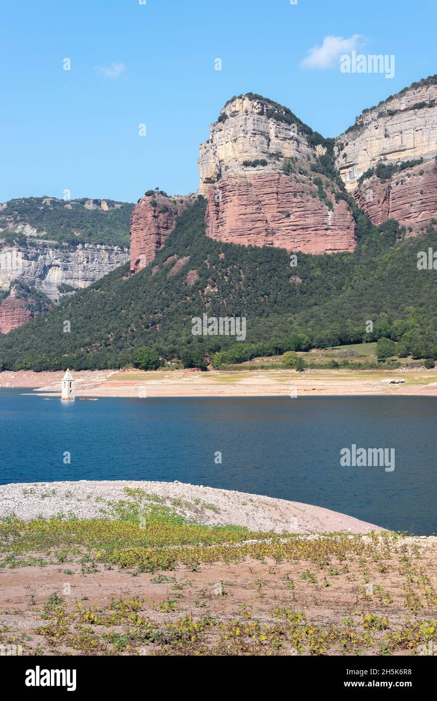 Der Stausee Sau und die Bergkette Las Guillerias mit dem unter Wasser gelegenen Glockenturm des Dorfes San Roman de Sau, Barcelona Stockfoto