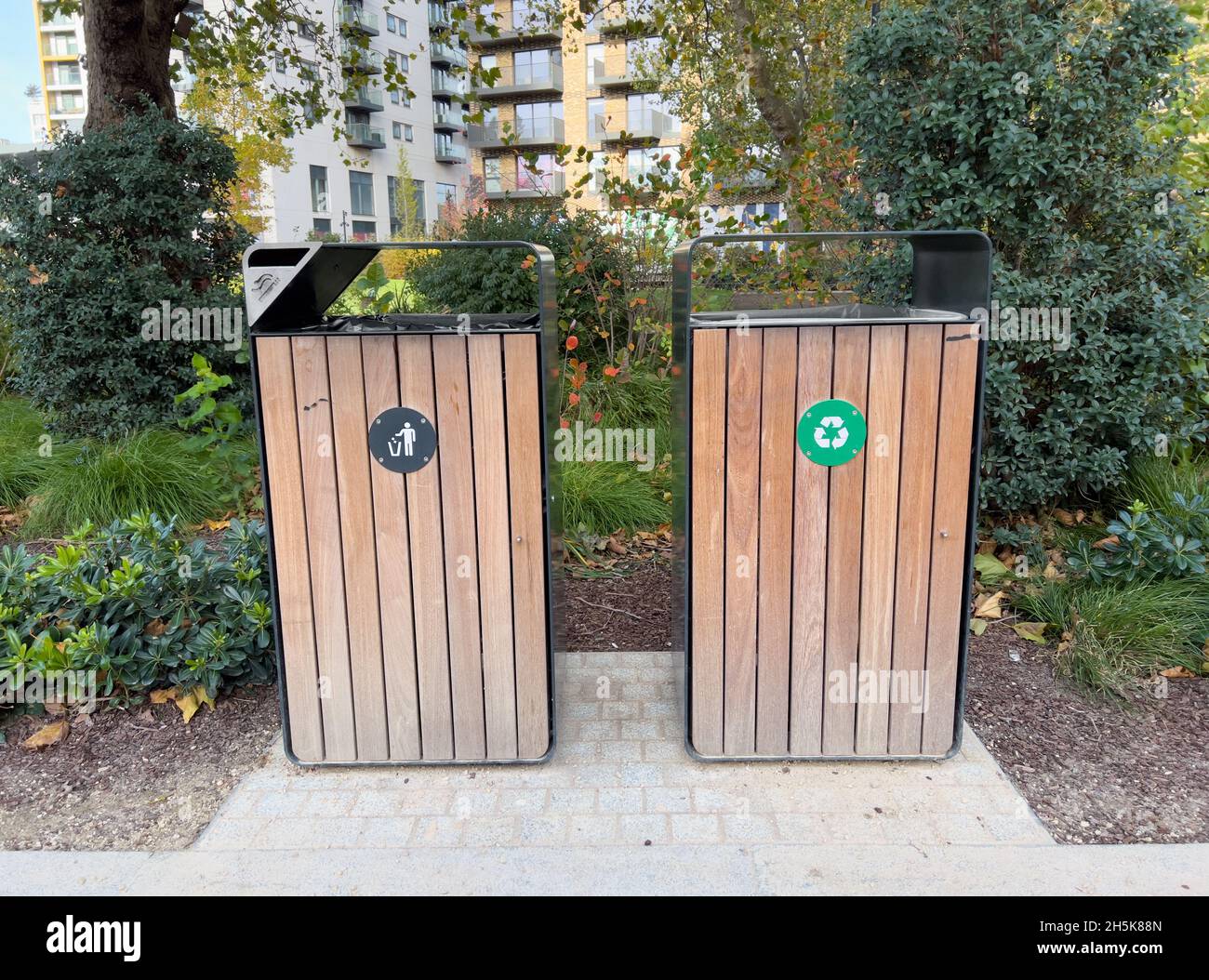 Trennen Sie Abfall- und Recyclingbehälter in einem sauberen öffentlichen Park Stockfoto