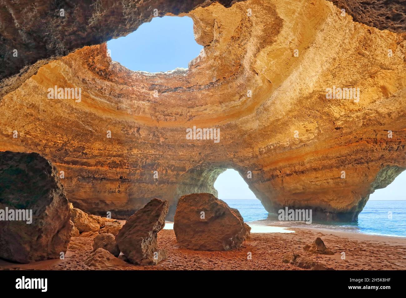 Sandsteinfelsen in der Benagil Cave, Innenansicht einer Meereshöhle entlang der Meeresküste der Algarve mit Sonnenlicht, das durch eine Öffnung scheint Stockfoto