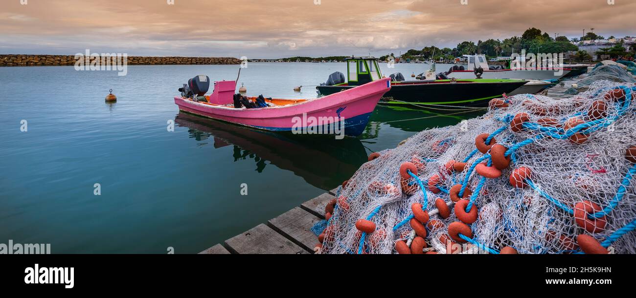Motorboote und Fischerboote vertäuten am Dock, gestapelt mit Fischernetzen im Hafen von Sainte Rose auf Basse-Terre; Guadeloupe, Französisch-Westindien Stockfoto