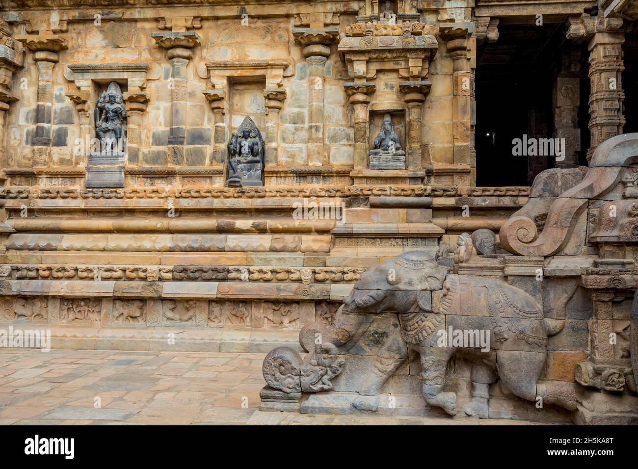 Drei Nischen mit hinduistischen Gottheiten in einer Wand und geschnitzte Elefantentreppe des Dravidian Chola-Ära Airavatesvara Temple; Darasuram, Tamil Nadu, Indien Stockfoto