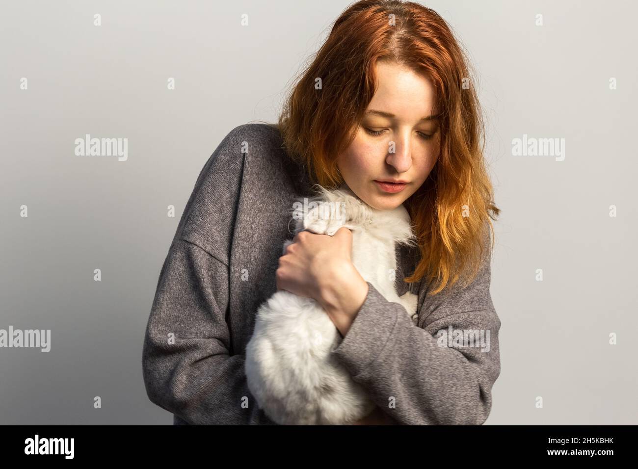 Traurige Frau, die ein Kaninchen hält. Tiertherapie Behandlung von Depressionen und anderen emotionalen Problemen Stockfoto