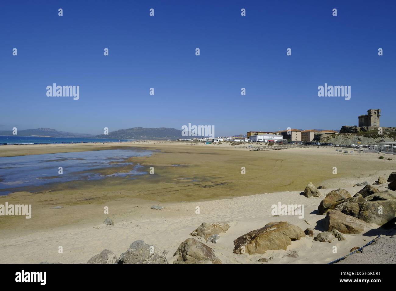Der Strand von Los Lances, an einem sonnigen Septembermorgen, der von Kitesurfern und Touristen überflutet ist, vom Damm aus gesehen. Tarifa, Costa de la Luz, Andalusien, Stockfoto