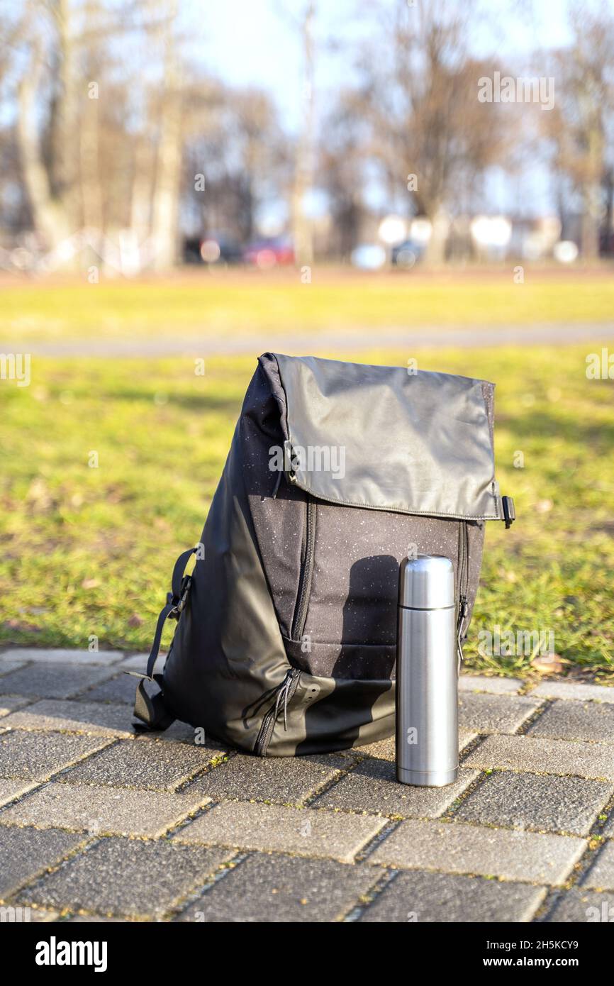 Sport wasserdichte Stoff schwarz großen Rucksack in der Nähe von Metall Thermos im Winter Park Stockfoto