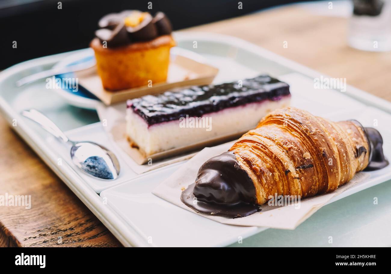 Ein Croissant, eine Portion Käsekuchen und ein Muffin mit Karottenkuchen Stockfoto