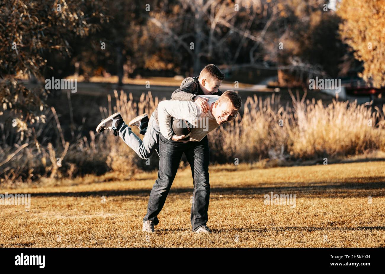 Vater spielt im Herbst mit seinem Sohn in einem Park Fußball; St. Albert, Alberta, Kanada Stockfoto