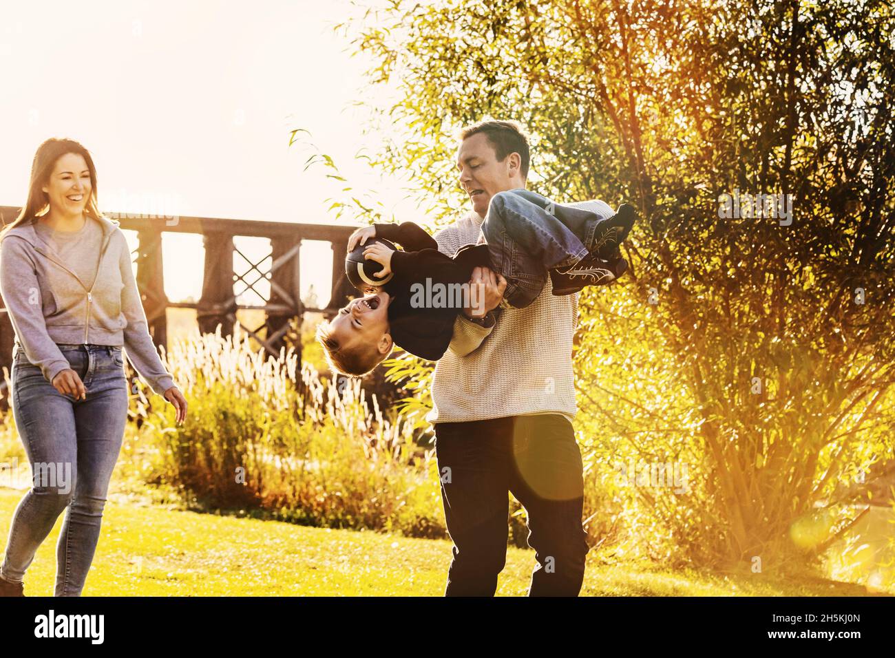 Junge Familie spielt im Herbst in einem Park zusammen Fußball; St. Albert, Alberta, Kanada Stockfoto