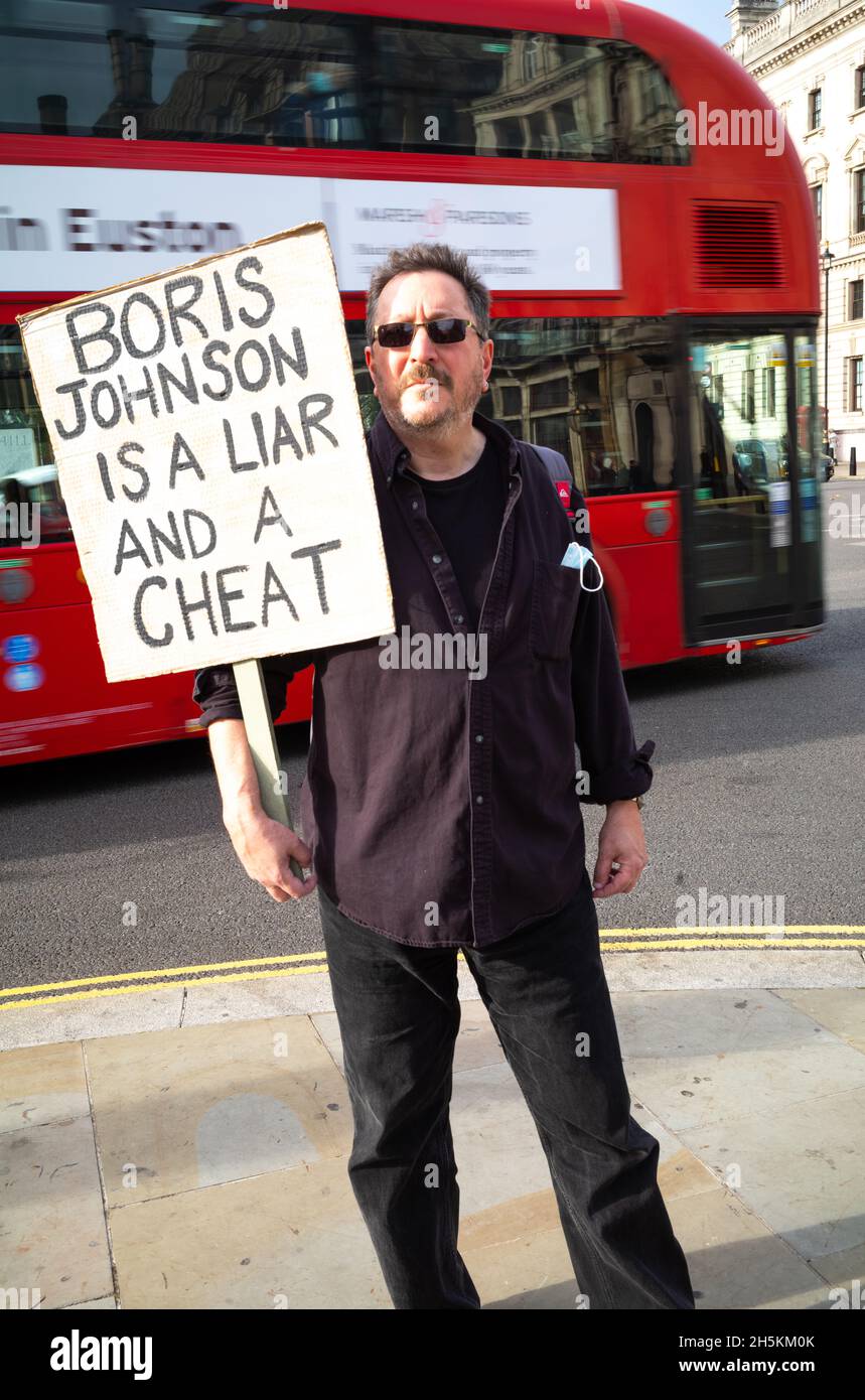 Ein Mann protestiert vor dem Londoner Parlamentsgebäude gegen Premierminister Boris Johnson und sagt, er sei ein Betrüger und ein Lügner. 8. November 2021 Stockfoto