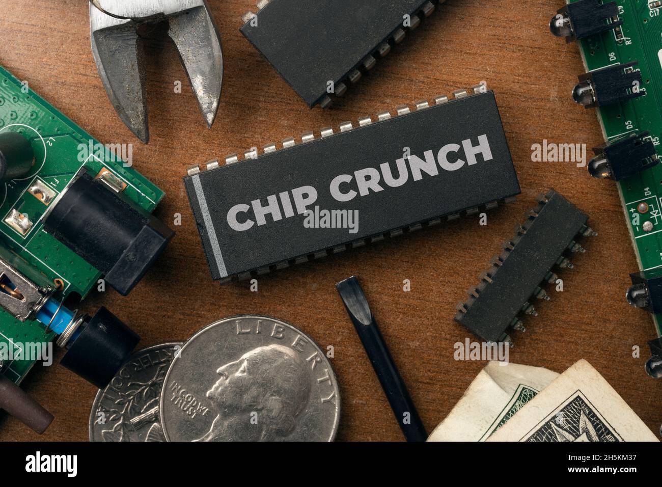 Chip Crunch (Halbleiterknappheit) Konzept: Einige integrierte Schaltung und elektronische Sachen auf einem Holztisch. Stockfoto