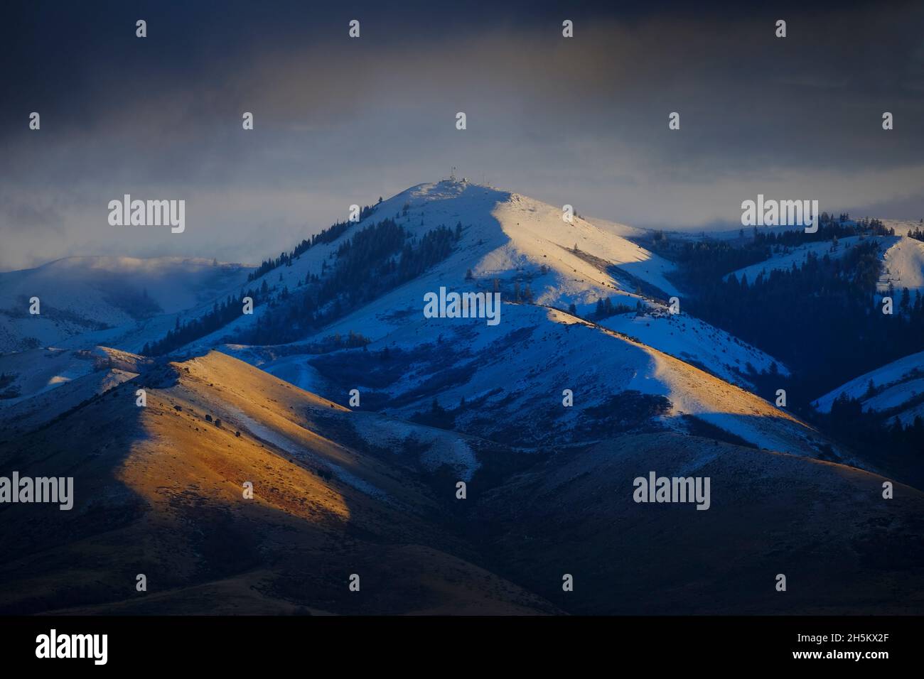 Berge bei Sonnenaufgang oder Sonnenuntergang mit Sturmwolken am Himmel Stockfoto