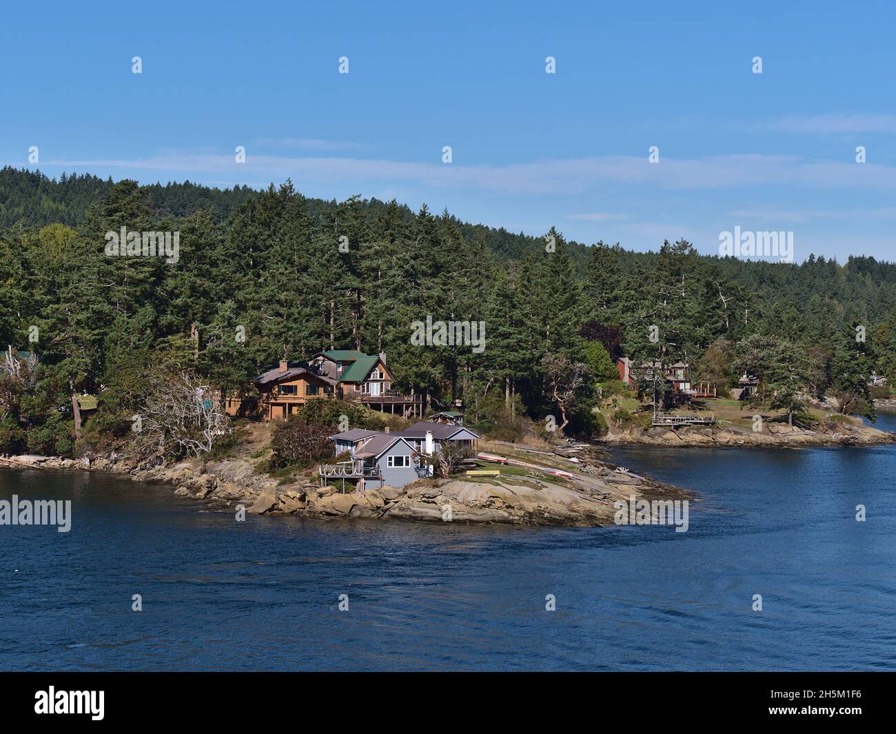 Idyllische Landschaft mit Wohnhäusern an der felsigen Küste von Galiano Island, Strait of Georgia, British Columbia, Kanada im Herbst. Stockfoto