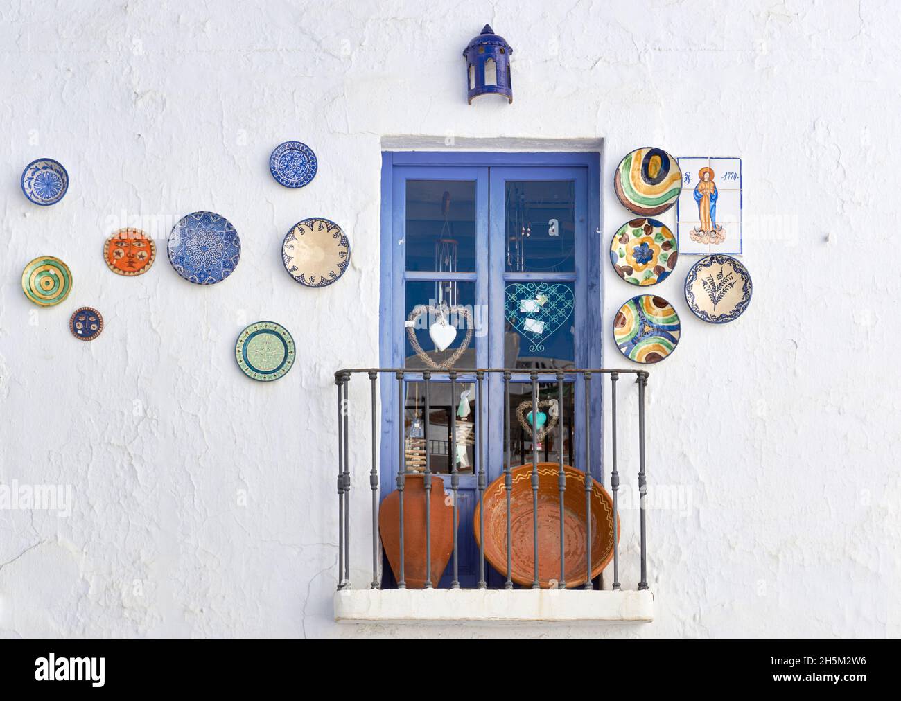 Ornamente hängen an einer Wand im Dorf Frigiliana, typische Straßen der Axarquia in Malaga. Andalusien, Spanien Stockfoto