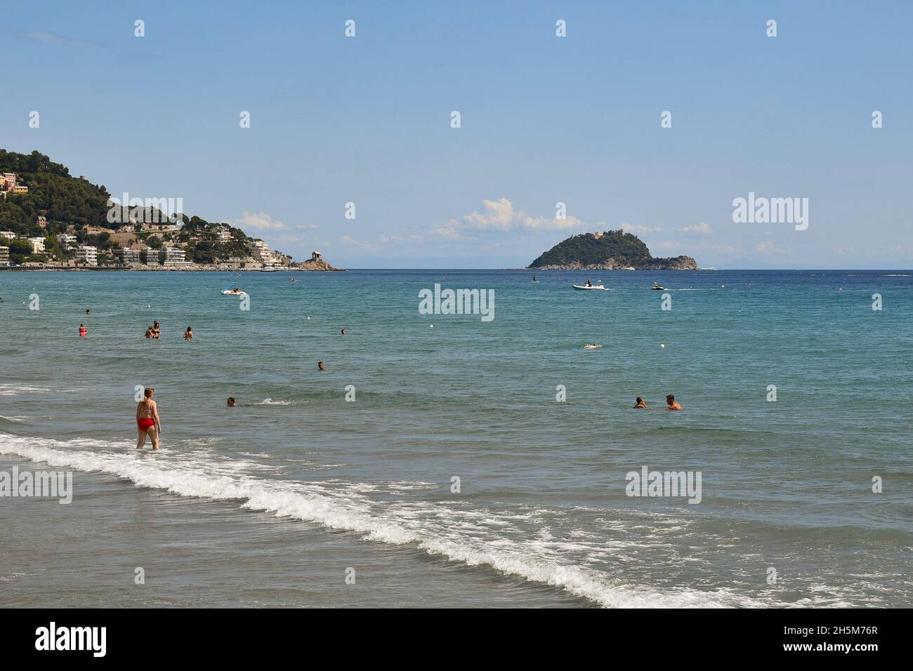 Seascape mit Menschen schwimmen am Ufer und die Gallinara Insel über dem Meereshorizont an einem sonnigen Sommertag, Alassio, Savona, Ligurien, Italien Stockfoto