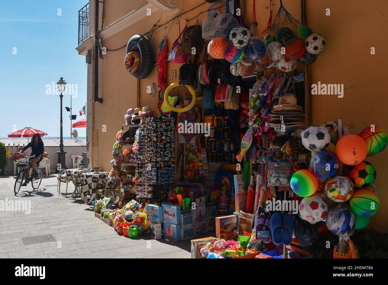 Ein Touristengeschäft, das Strandspielzeug und Souvenirs an der Uferpromenade von Alassio an einem sonnigen Sommertag verkauft, Savona, Ligurien, Italien Stockfoto