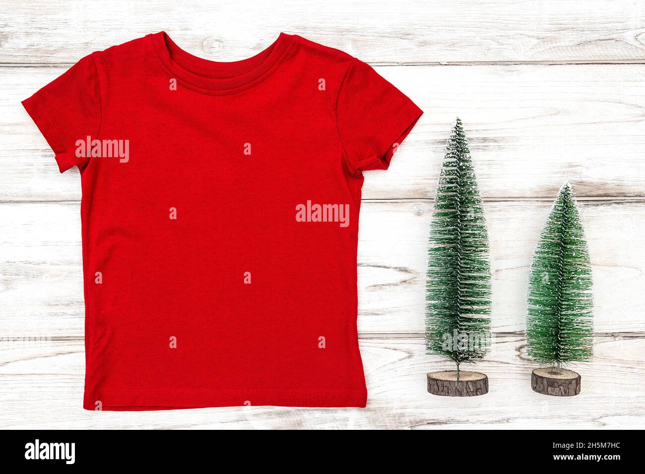 T-Shirt-Mockup mit Weihnachtsbaumschmuck. Rotes T-Shirt Stockfoto