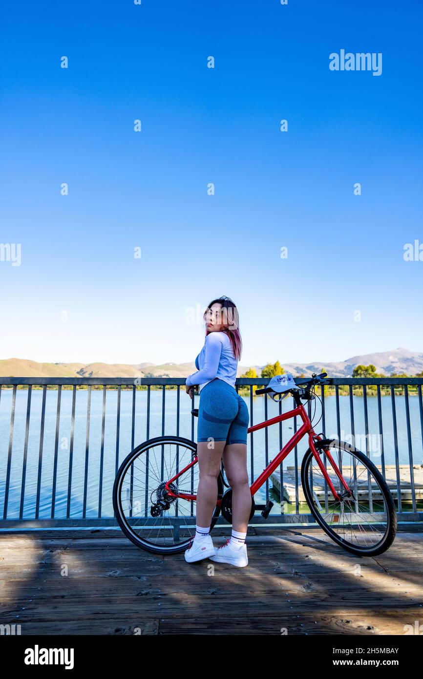 Junge asiatische Frau mit Fahrrad am Lakeside Boat Dock Stockfoto