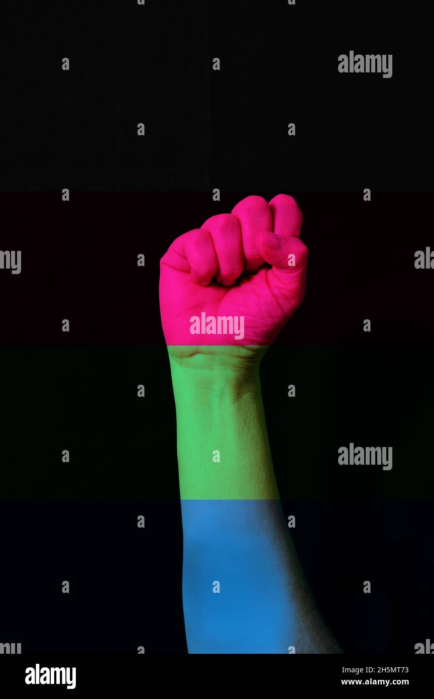 Faust Hand mit Polysexual Stolz Flagge gemustert Isolate auf schwarz. LGBTQ+-Rechtekonzept Stockfoto
