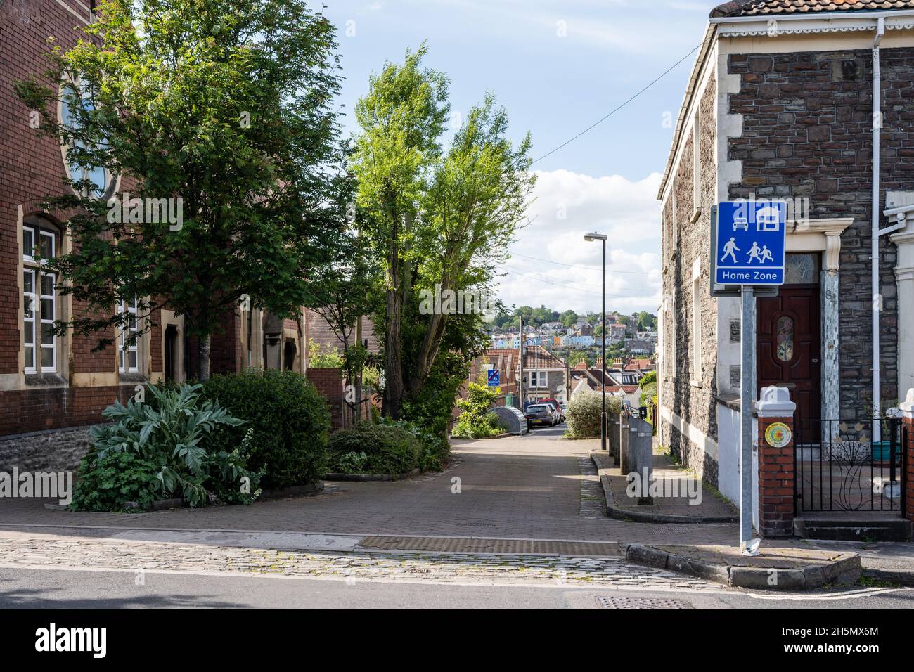 Straßenbäume und Sträucher tragen in einer Wohnstraße in Bristol zur Beruhigung des Verkehrs und zur Widerstandsfähigkeit des Klimas bei. Stockfoto